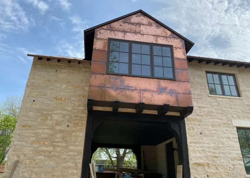 Copper metal panel facade on a stone building for Roof Repair in Overland
